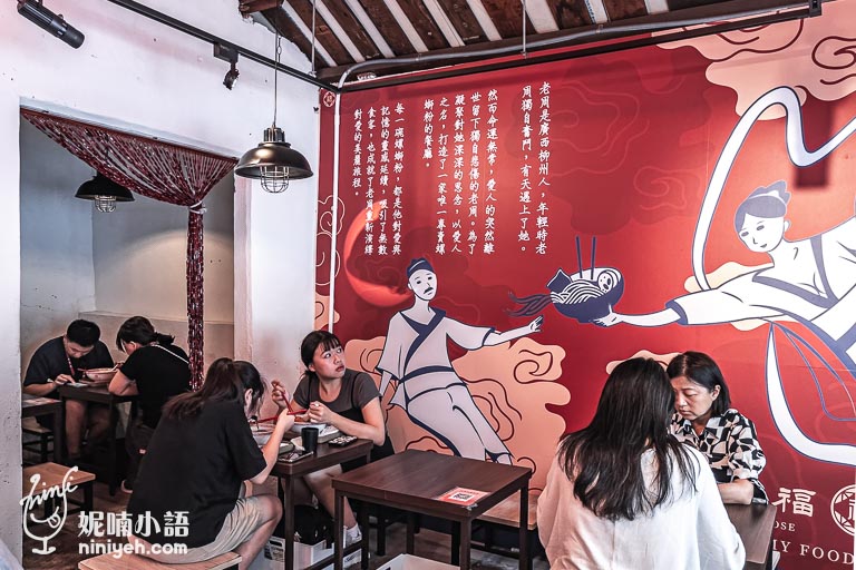 螺螄福餐廳內部，顧客們正在用餐，背景牆上有大型的品牌故事壁畫，以紅色為主色調，描繪了餐廳創立的故事，增添了文化氛圍。整體環境溫馨舒適，展現出螺螄福的傳統與現代融合風格，為顧客提供了別具特色的用餐體驗。