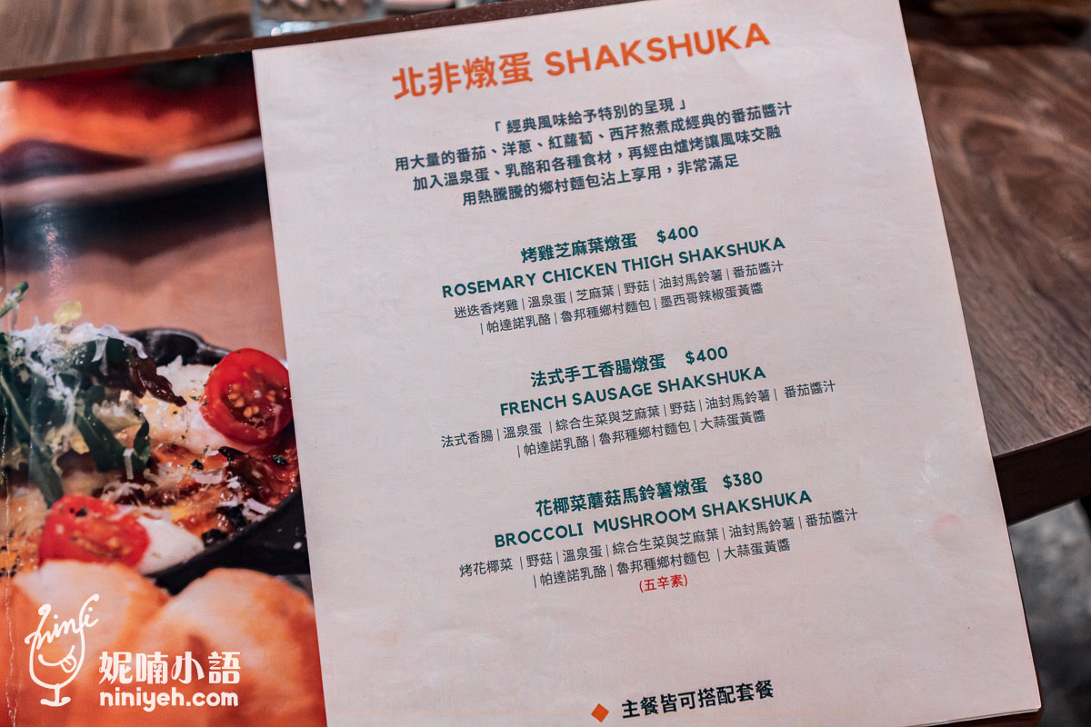 這張圖片展示了察爾斯廚房（Charles' Kitchen）的北非燉蛋（Shakshuka）菜單，這是一道以番茄醬汁為基底的經典北非料理，搭配不同的食材來豐富口感。以下是部分選項介紹：

烤雞芝麻葉燉蛋（NT$400）：搭配迷迭香烤雞腿排、芝麻葉、野菜，並以番茄醬汁與油封馬鈴薯烹調，風味獨特。
法式手工香腸燉蛋（NT$400）：法式香腸與溫泉蛋、野菜搭配，融合番茄醬汁的濃郁口感，十分美味。
花椰菜蘑菇馬鈴薯燉蛋（NT$380）：這道素食選擇包含烤花椰菜、蘑菇、馬鈴薯和野菜，搭配經典番茄醬汁，適合素食者享用。
每道燉蛋均可搭配套餐，讓顧客享受更完整的美食體驗。