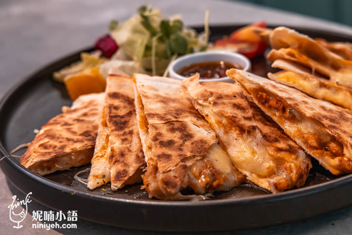 禾多餐酒館墨西哥薄餅特寫,餅皮金黃帶焦香,內餡夾有融化起司與肉醬,搭配小碟醬料與生菜沙拉,擺盤精緻誘人。