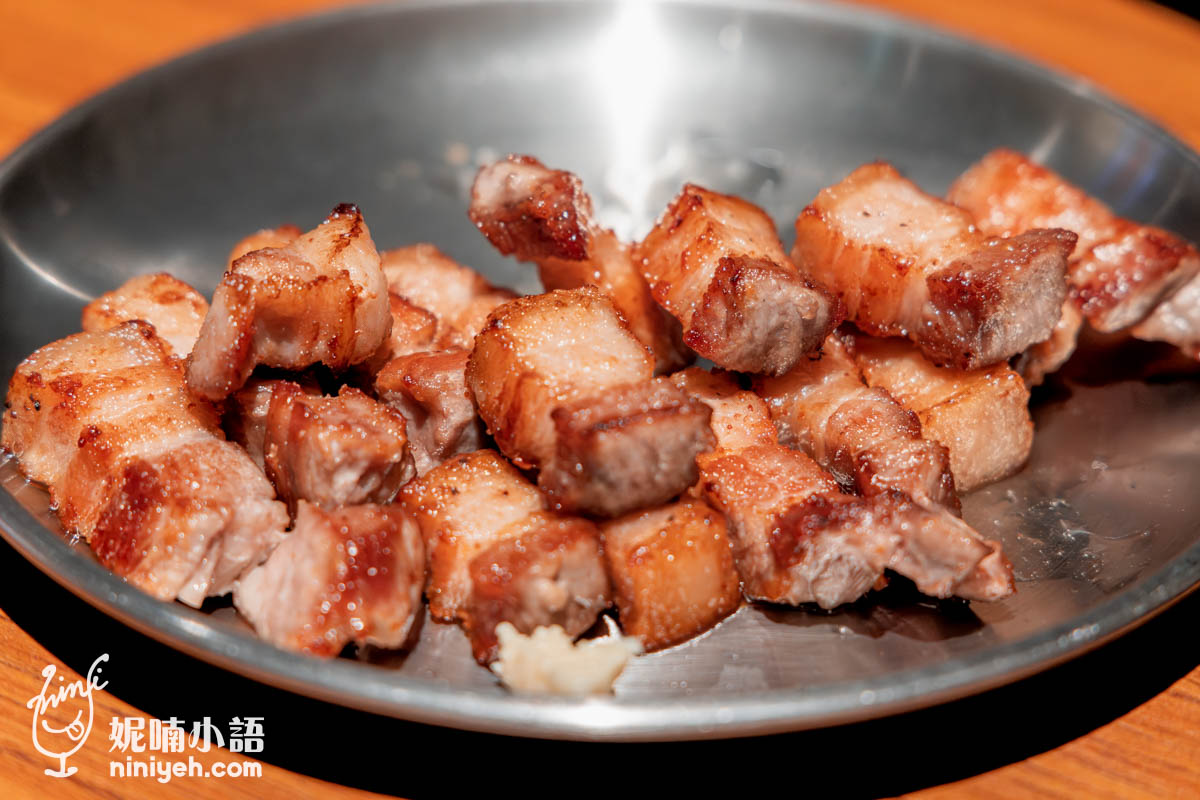 烤炙後的豬五花儘管瑟縮捲起，厚度仍高出一般餐廳，皮油筋肉在嘴裡迸發，邊角焦黑起泡嚼起來口感立體，包著生菜、辣辛奇、蒜片一起塞入口，感受汁水在嘴裡竄動的繁複滋味就對啦，還有霜降松阪豬彈脆更有力道，像吃到軟骨般的韌脆，不用沾任何醬料單吃都香，超涮嘴。