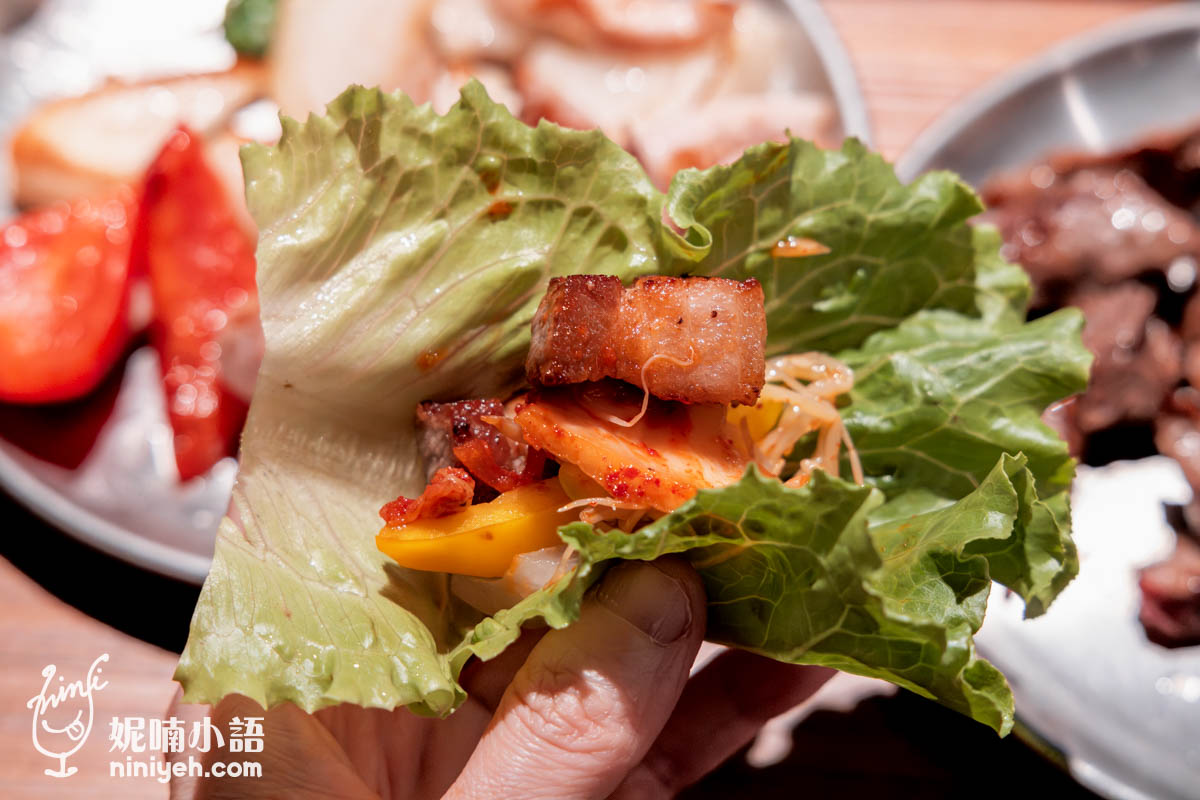 烤炙後的豬五花儘管瑟縮捲起，厚度仍高出一般餐廳，皮油筋肉在嘴裡迸發，邊角焦黑起泡嚼起來口感立體，包著生菜、辣辛奇、蒜片一起塞入口，感受汁水在嘴裡竄動的繁複滋味就對啦，還有霜降松阪豬彈脆更有力道，像吃到軟骨般的韌脆，不用沾任何醬料單吃都香，超涮嘴。