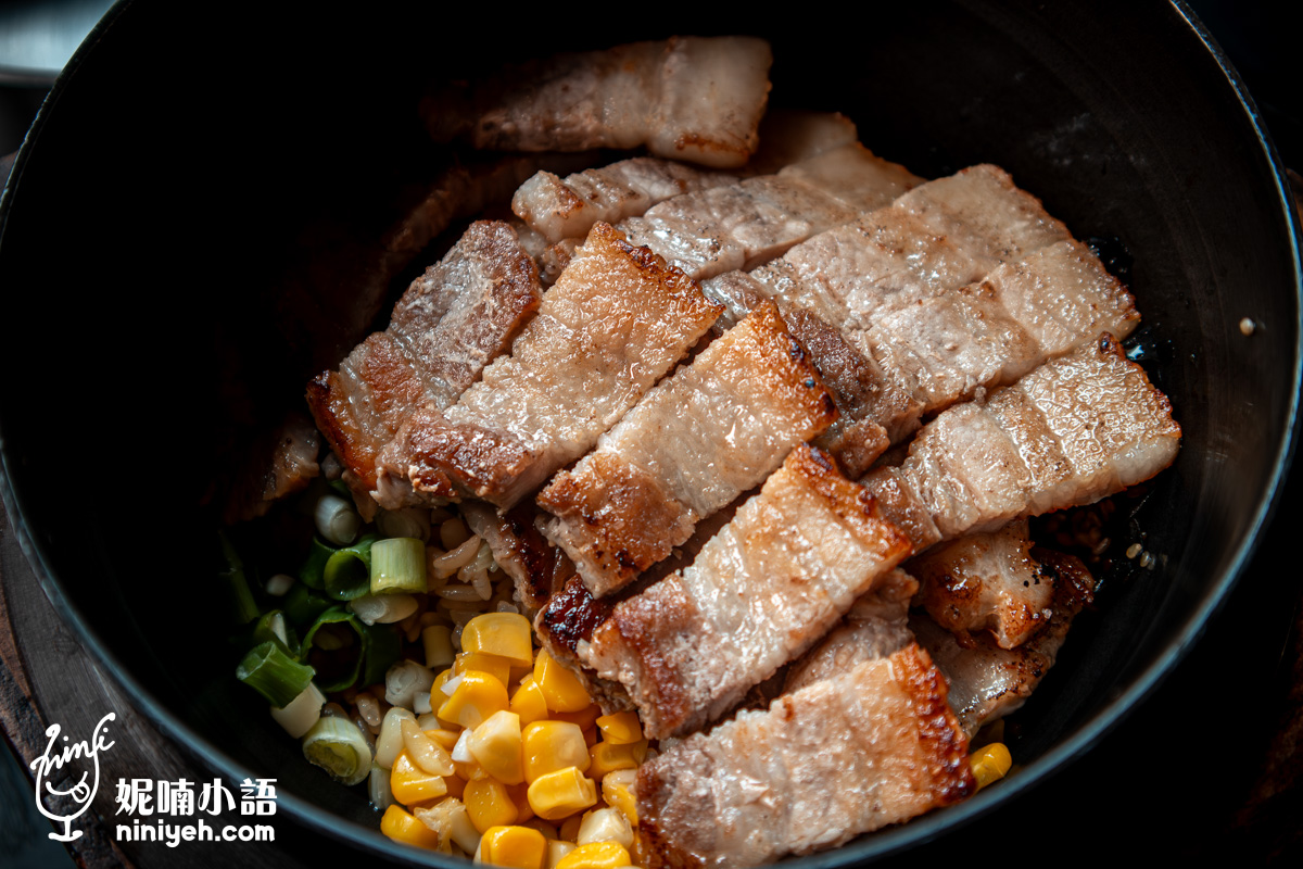 士林「金美麗人」肉量加倍(200g)的海鹽烤五花肉釜飯近焦特寫,層層堆疊的烤五花肉片展現酥脆外皮與多汁肉質,下方襯著誘人的玉米粒與鮮綠蔥花。