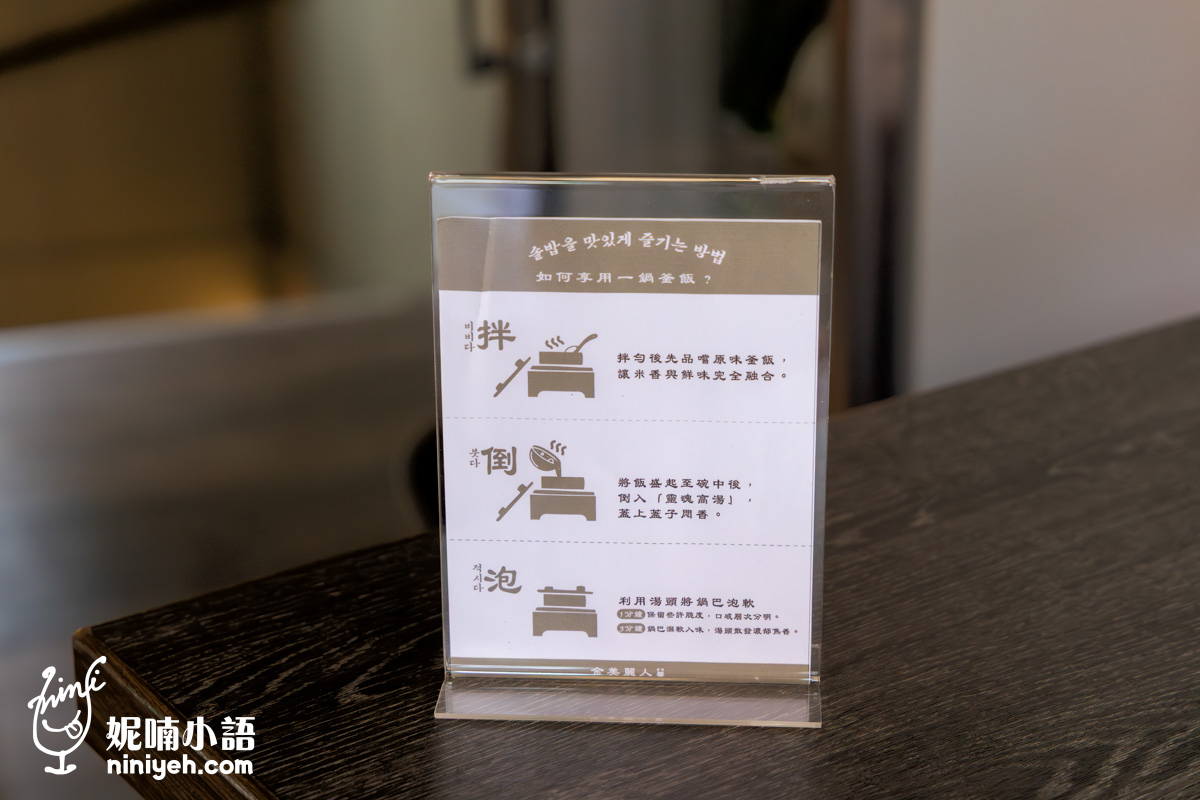 「金美麗人」餐桌上的「如何享用一鍋釜飯」中韓文對照吃法步驟說明牌,詳細引導顧客遵循「拌、倒、泡」三步驟來體驗道地的正宗韓式釜飯一鍋兩吃。
