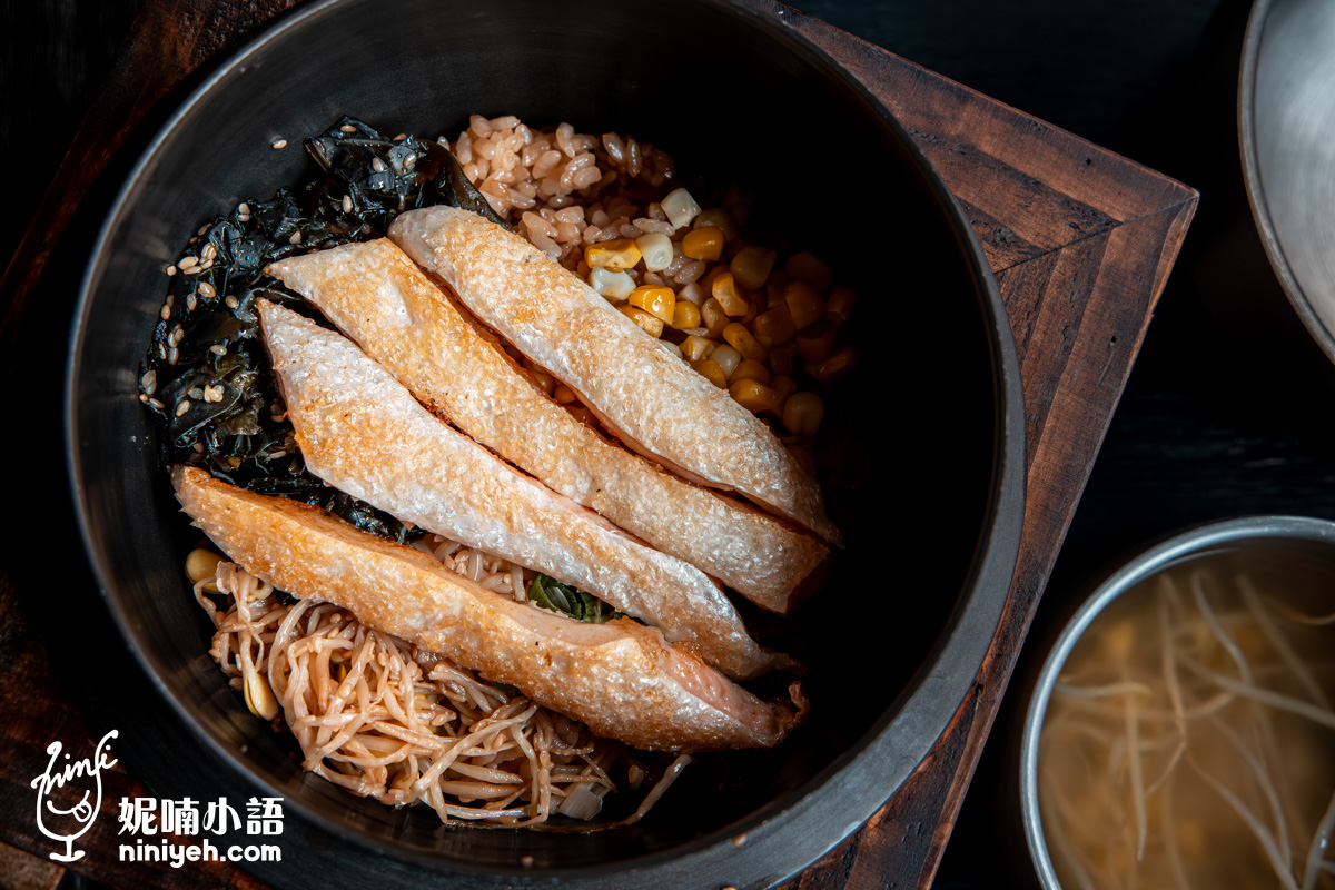 台北士林「金美麗人」海鹽烤鮭魚肚釜飯的俯瞰特寫,經直火炙烤到微焦、呈現粉橙色澤的肥美帶皮鮭魚肚,整齊排放在炊煮好的玉米米飯上。