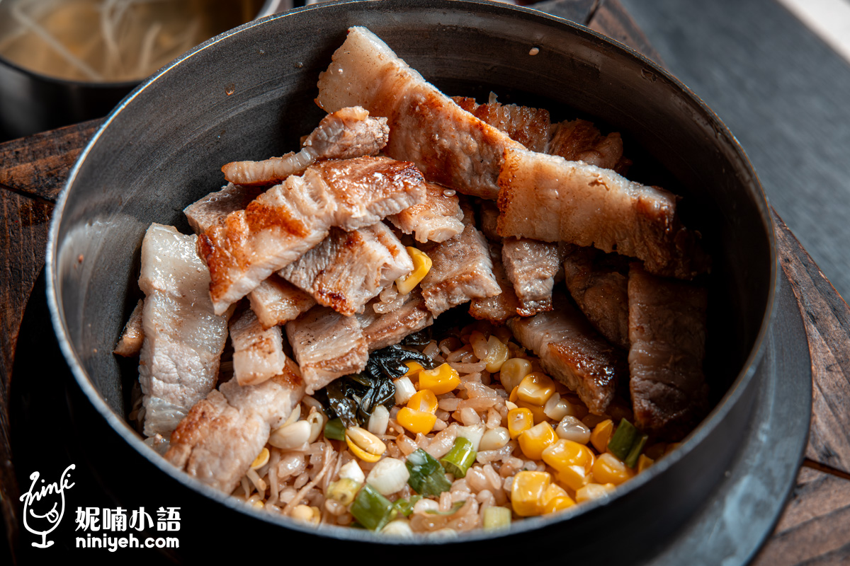 「金美麗人」直火烹煮的韓式釜飯特寫,攪拌後,焦香的烤豬五花肉片與暖黃色、粒粒分明且充滿麻油香的玉米米飯完美融合。