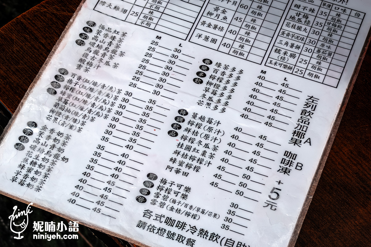 台北小巨蛋美食緯大雞排紙本訂購單飲料區特寫。清楚列出茶飲、奶茶、養樂多、特調等多款解膩冷飲的價目表，並標示左列飲品加椰果或咖啡凍只需加5元。