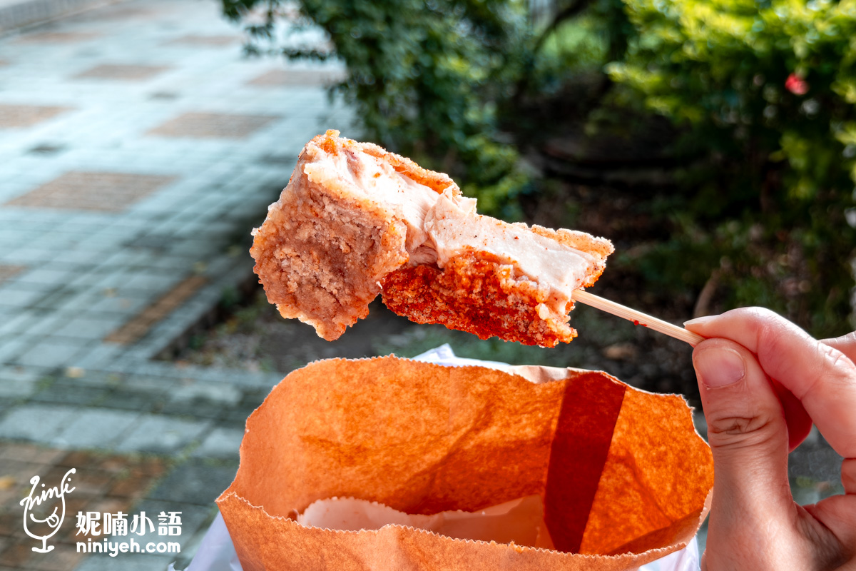 台北小巨蛋美食緯大雞排咬開後的斷面特寫。用竹籤串起的炸雞塊，清楚可見極度厚實且白嫩多汁的肉質，搭配外層撒上特製辣粉的金黃酥脆麵衣。