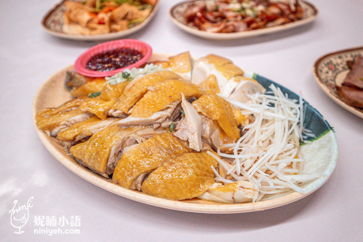 慶豐麵店的白斬雞切盤,雞皮呈現金黃油亮色澤,盤側附有大量嫩薑絲與一小碟辣椒醬油。
