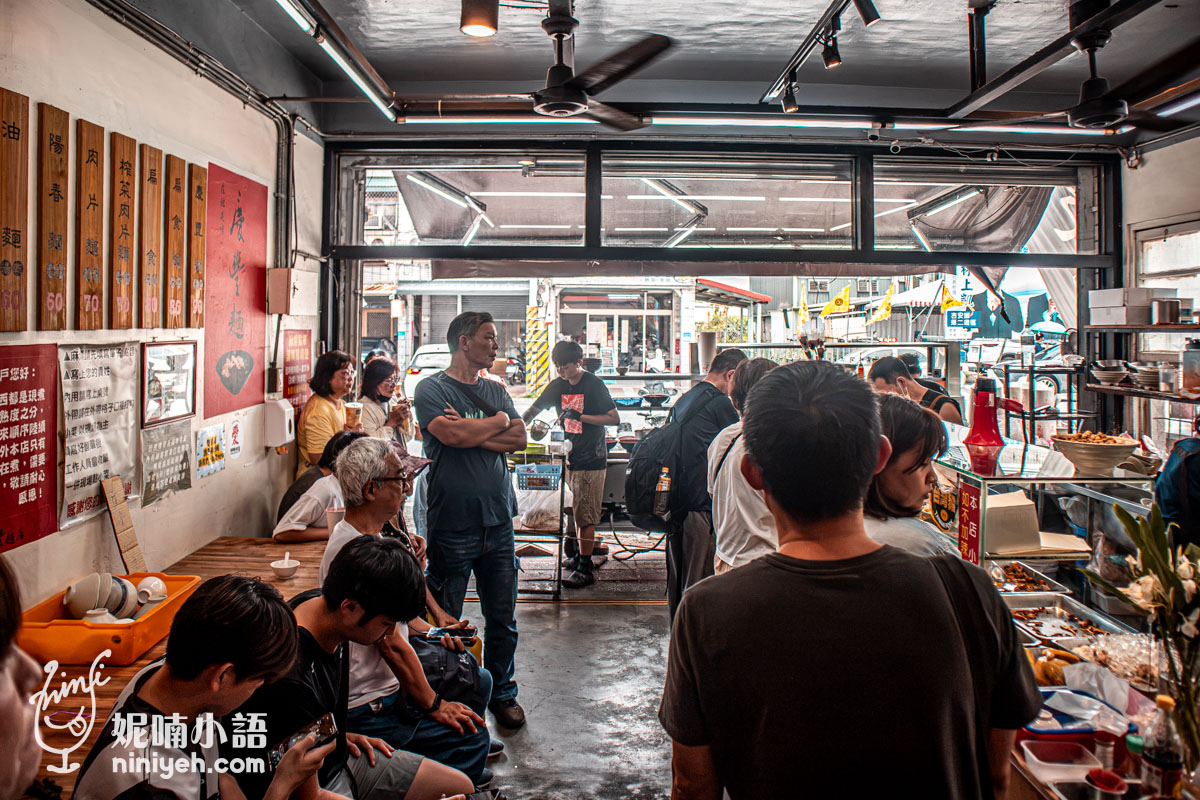 慶豐麵店店內前半部的排隊點餐人潮,牆上掛著木製菜單看板,右側為滷菜選購櫃檯。
