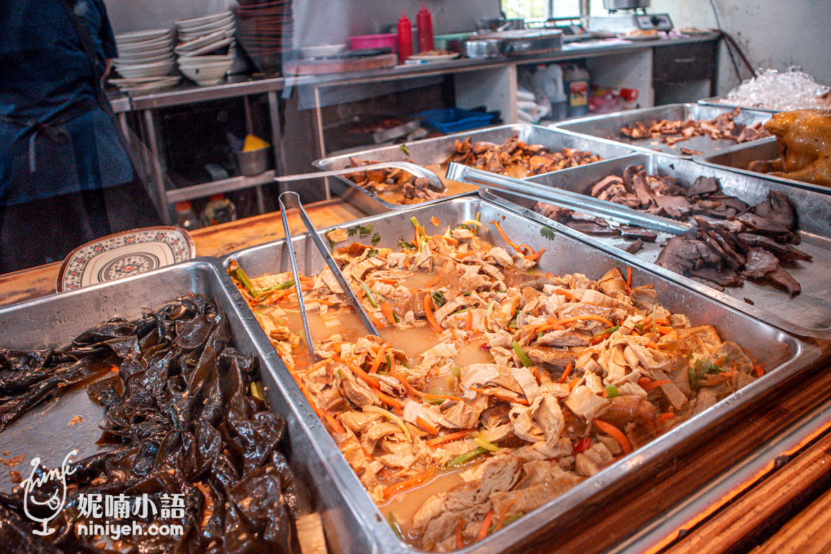 慶豐麵店的滷菜檯特寫,不鏽鋼托盤中盛裝著煙燻豆皮、海帶與各式豬雜小菜切盤。