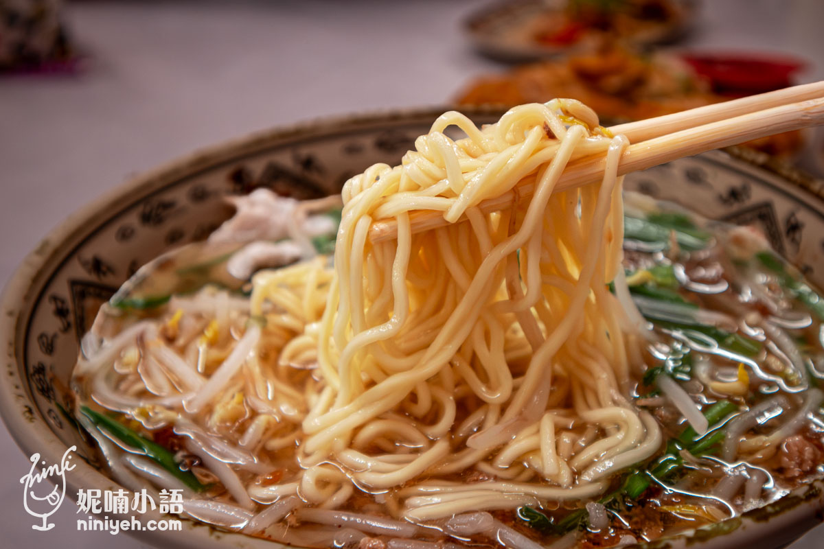 用筷子夾起大把吸飽濃郁湯汁的慶豐麵店肉片拉麵,麵條彈牙且帶有古早味油蔥香。