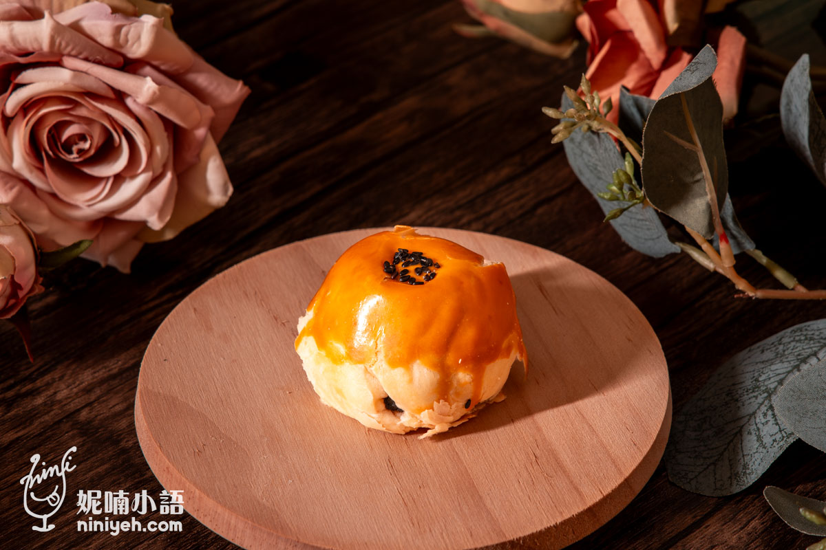 芝初黑芝麻Q潤蛋黃酥單顆外觀特寫,使用進口安佳奶油烤製的金黃色多層次酥皮,頂部點綴黑芝麻粒