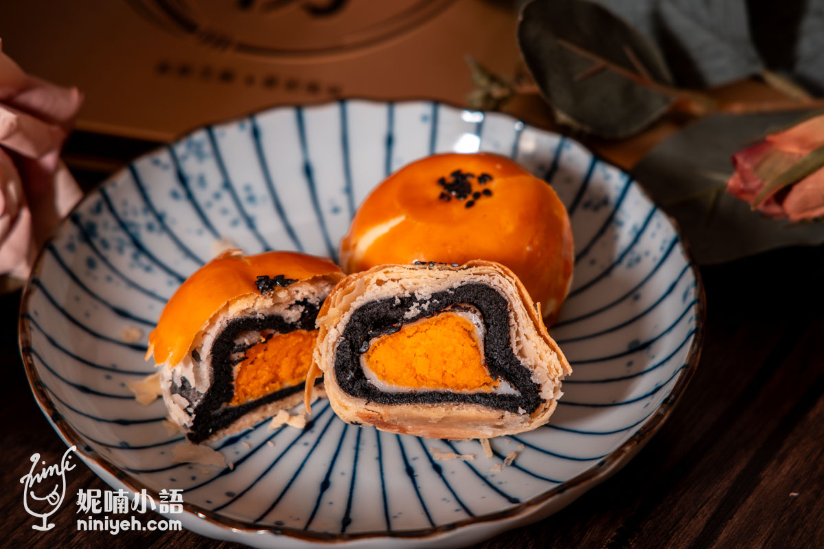 芝初黑芝麻Q潤蛋黃酥橫切面特寫:清晰可見多層次酥皮、濃郁黑芝麻內餡、Q彈白玉麻糬層與飽滿的鹹蛋黃,完美呈現減糖不甜膩的口感層次。
