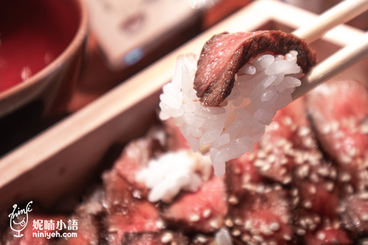 用筷子夾起搭配 Q 彈土鍋白飯的炭烤近江牛赤身肉片