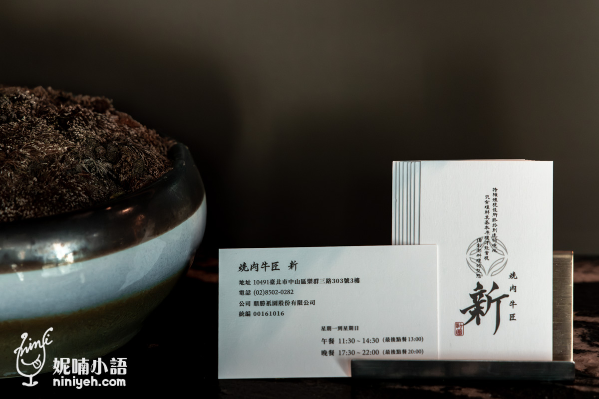 燒肉牛匠新 放置於質感名片架上的店家名片，印有營業時間與地址資訊
