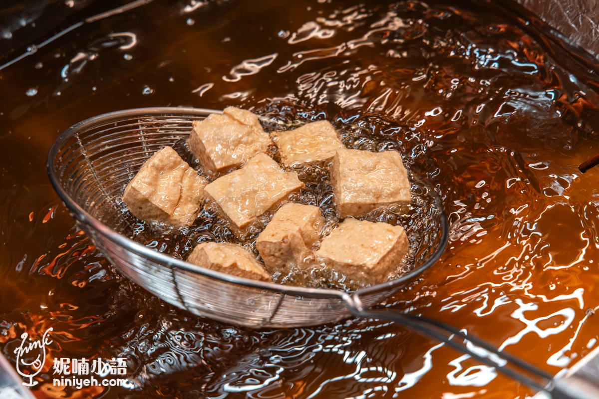 臭豆腐在清澈的炸油中高溫油炸並以濾網撈起