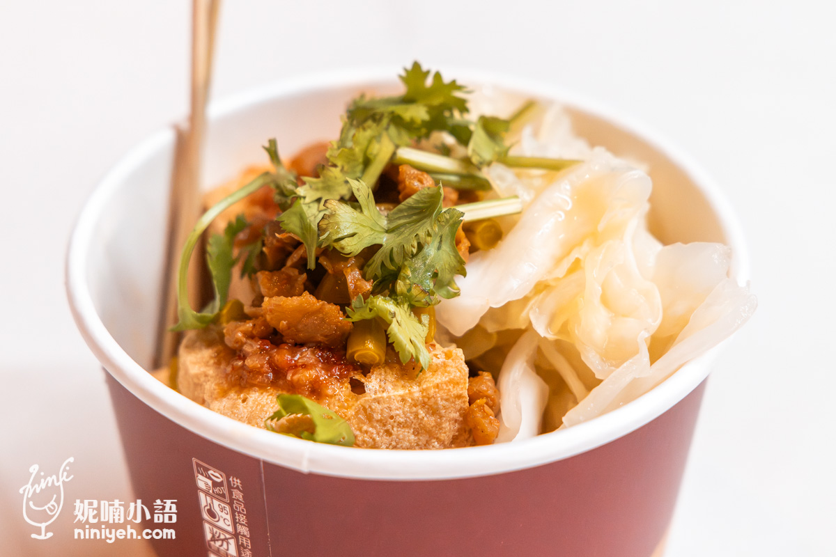 裝滿臭豆腐並搭配台式泡菜、酸豇豆與香菜的豐富特寫