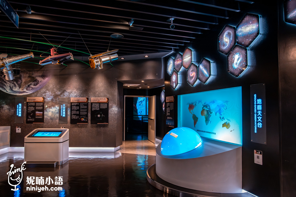 地面天文台展區，設有一個藍色發光半球體與彩色世界地圖背板，充滿濃濃的學術探索氛圍