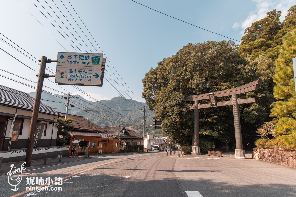 宮崎高千穗街道景色,路旁立有高千穗神社與高千穗峽路標,右側為神社木造鳥居與茂密綠樹