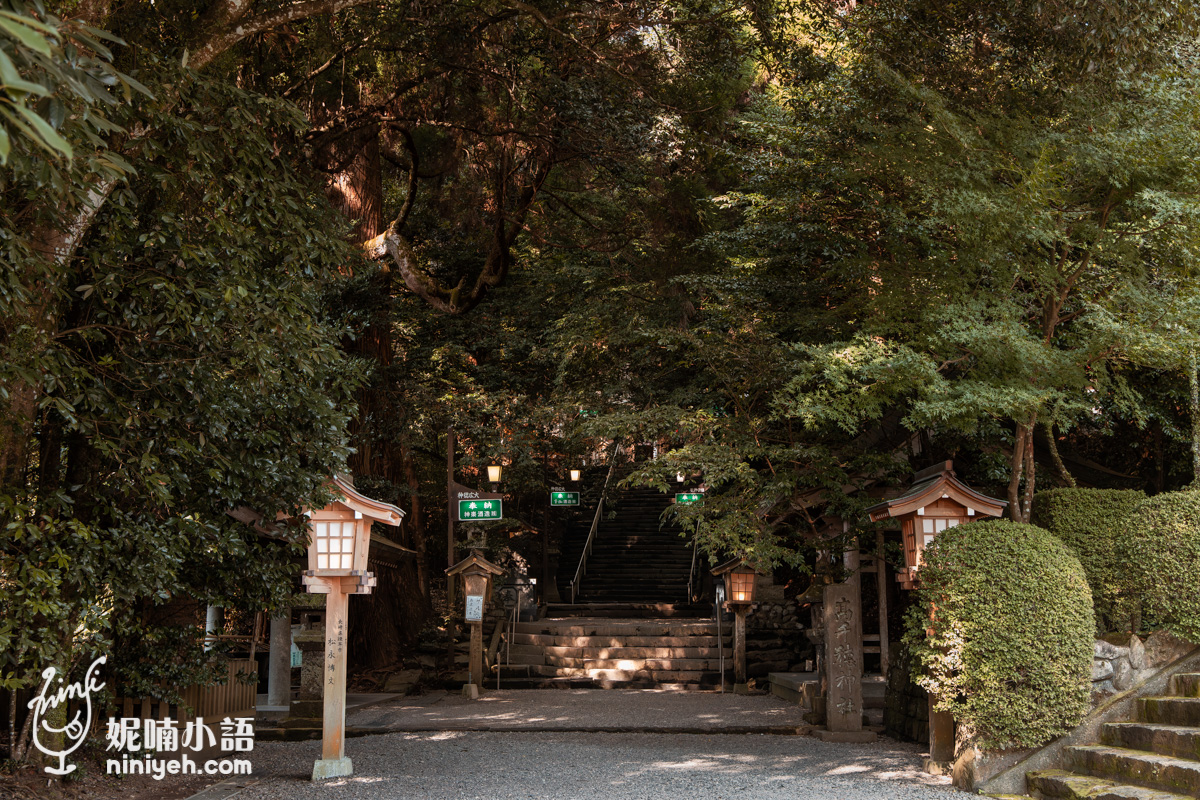 宮崎高千穗神社境內參道,參天古木遮蔽天際,碎石步道兩側立有木造燈籠與通往本殿的石階