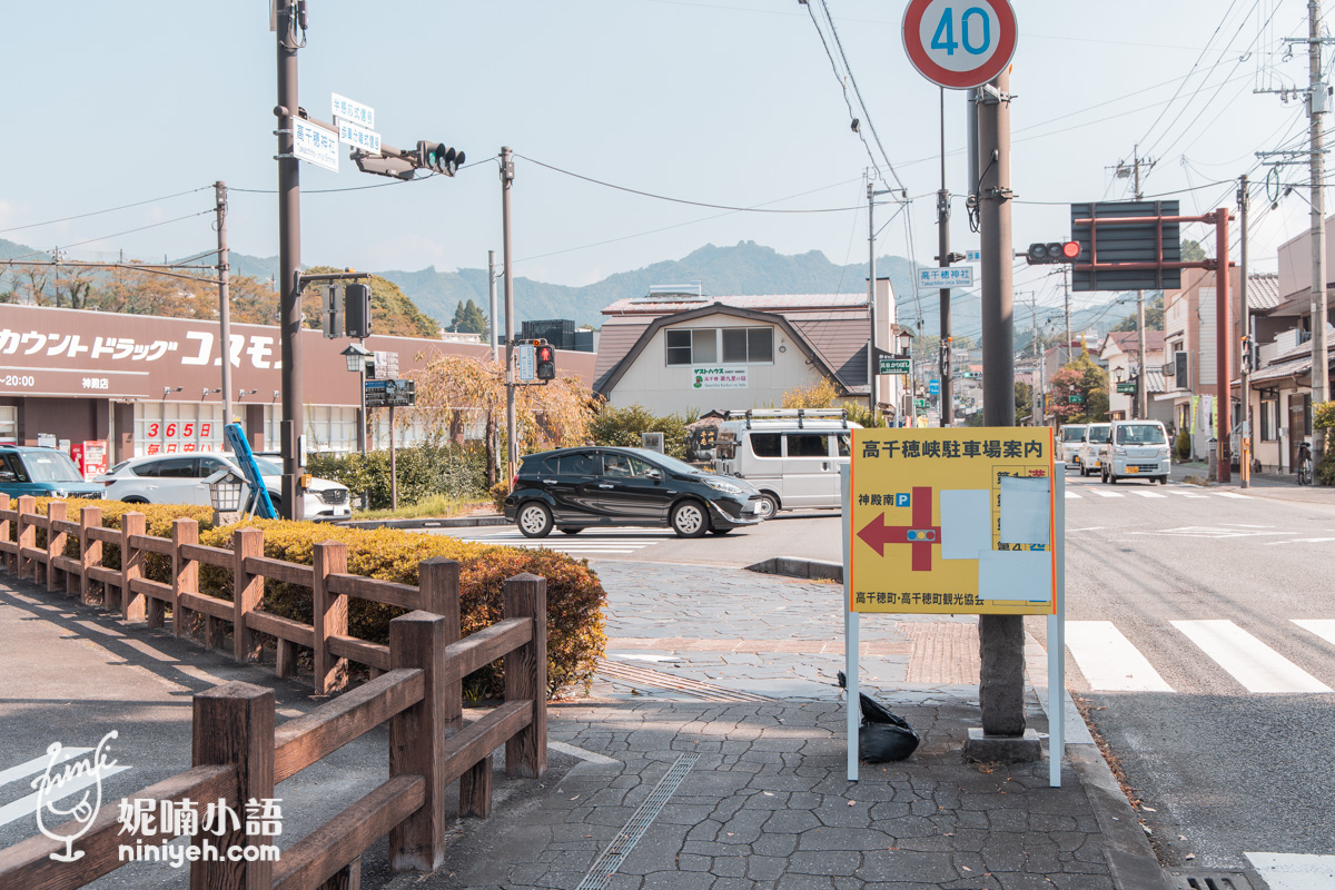 高千穗神社周邊路口設置的黃色高千穗峽停車場案內告示牌,指引自駕車輛停放方向